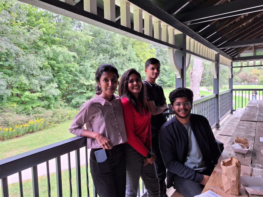 A group of young people sitting at a picnic table.
