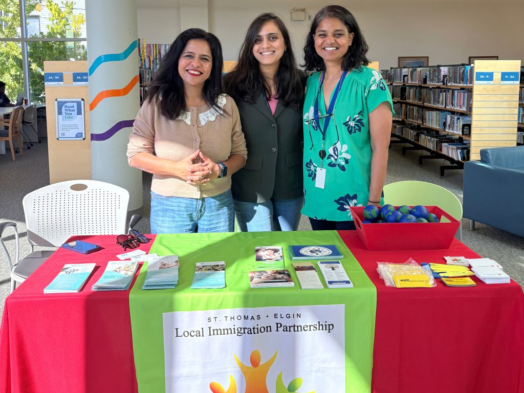 Information table with brochures and St. Thomas-Elgin Local Immigration Partnership banner at St. Thomas Public Library during Community Connections Info Share.